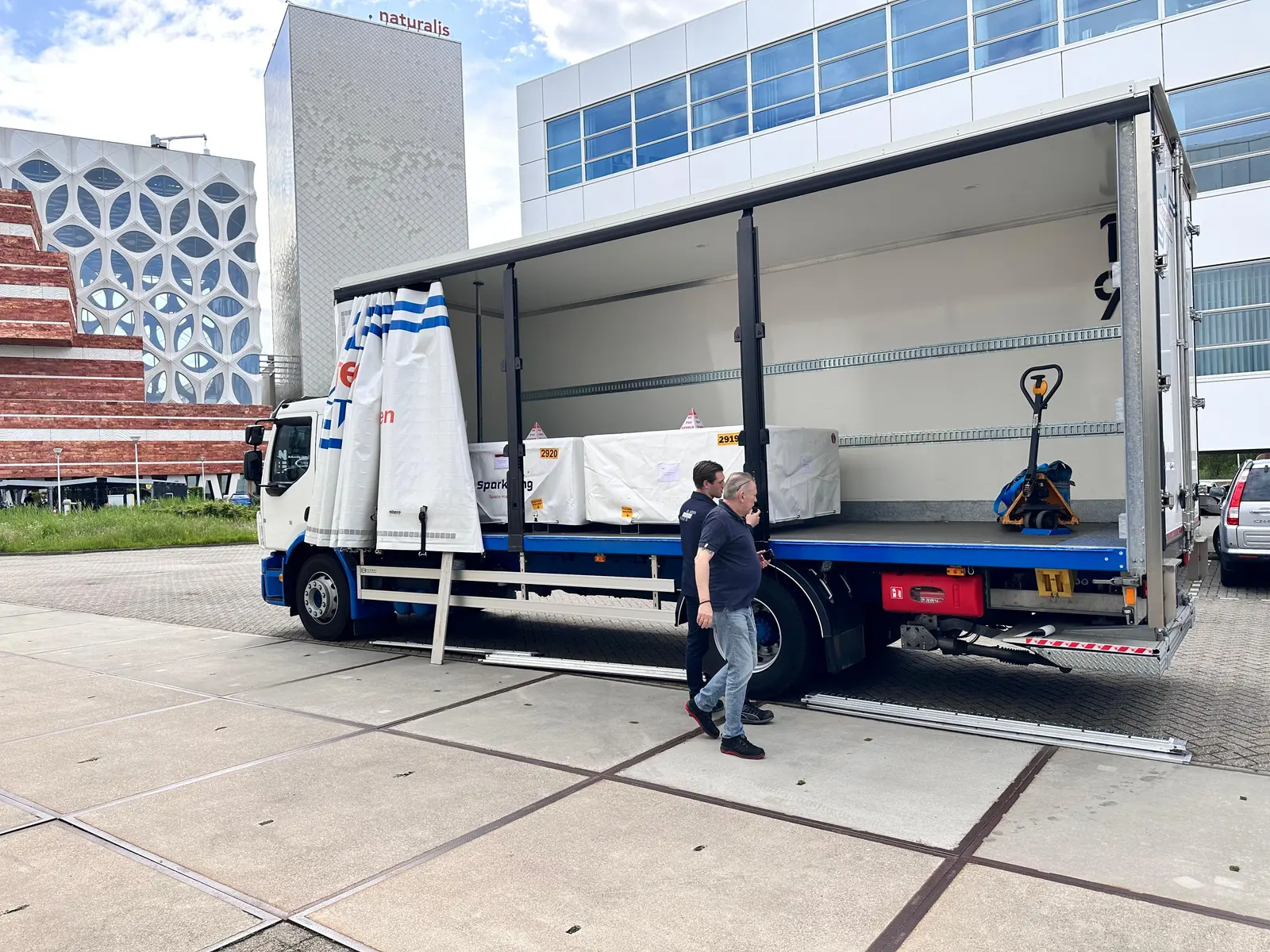 Wrapped crates loaded onto a curtain-sider for an on-site delivery