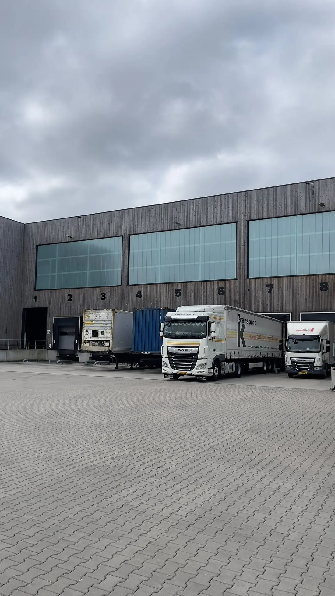 The Reibel warehouse with numbered loading docks and trucks