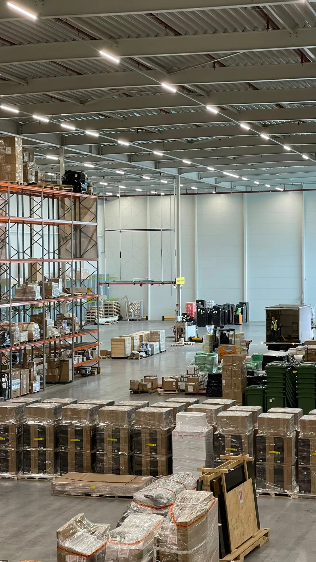 The warehouse floor with wrapped pallets and forklifts